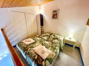 een kleine slaapkamer met een bed met handdoeken erop bij Studio Bord de mer avec terrasse in Saint-Georges-de-Didonne