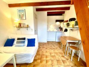 een kleine kamer met een bed en een keuken bij Studio Bord de mer avec terrasse in Saint-Georges-de-Didonne