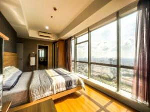 スラバヤにあるGrand Sungkono Lagoon Apartment 2BR Surabaya by Le Ciel Hospitalityのベッドルーム1室(ベッド1台、大きな窓付)