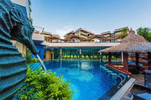 a pool at a resort with a dolphin fountain at Chalong Miracle Lakeview in Chalong