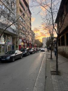 uma rua da cidade com carros estacionados na berma da estrada em New Studio near New Bazaar - Tirana City Center em Tirana