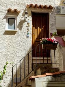 a building with a door and a flower pot on a balcony at Casa Vela in Cefalù