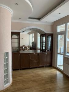 a large kitchen with wooden cabinets and a large window at Bedroom + Living Large Apartment 75m2 in Chişinău