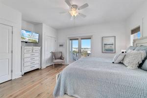 una camera da letto bianca con un letto e un ventilatore a soffitto di Family Getaway! Blue Bungalow w Pool! 4min Walk to Beach! a Gulf Shores Altre 49 foto