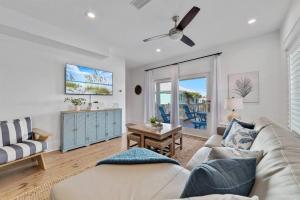 un soggiorno con un divano e un tavolo di Family Getaway! Blue Bungalow w Pool! 4min Walk to Beach! a Gulf Shores