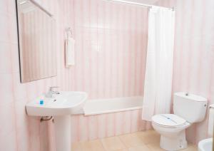 y baño con aseo y lavamanos. en Hotel La Perdi, en Sant Mateu