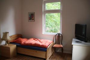 1 dormitorio con cama, ventana y escritorio en Paschen Monteurzimmer, 