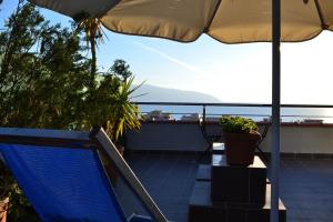 een balkon met een stoel en een parasol bij Seaview Penthouse Terrace & Garage in Vlorë