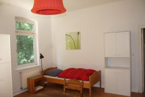 a bedroom with a bed with a red blanket on it at Paschen Monteurzimmer 