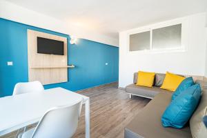 ein Wohnzimmer mit einem Sofa und einem TV in der Unterkunft New Kensington Apartments - Econotels in Magaluf