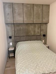 a bedroom with a bed with a large headboard at Apartament Natalia in Mrągowo