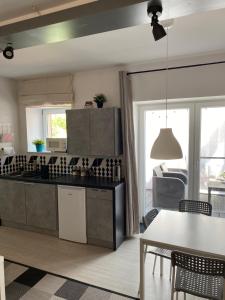 a kitchen with a table and a dining room at Apartament Natalia in Mrągowo