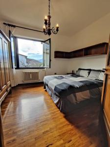 1 dormitorio con cama grande y ventana grande en Casa Ersilia, en Lierna