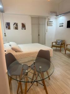 1 dormitorio con 1 cama, mesa de cristal y sillas en En el corazón de la ciudad! en Buenos Aires