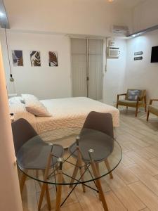 a bedroom with a bed and a glass table and chairs at En el corazón de la ciudad! in Buenos Aires