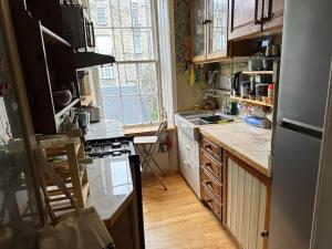 eine Küche mit einem Kühlschrank und einem Herd Top-Backofen in der Unterkunft Very central 2 bedroom flat in World Heritage Site in Edinburgh