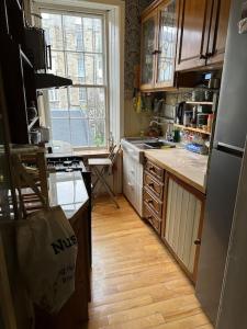 eine Küche mit Holzböden und einem großen Fenster in der Unterkunft Very central 2 bedroom flat in World Heritage Site in Edinburgh