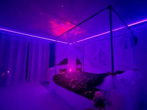 a purple room with a bed with a purple ceiling at Suite de Charme - So Chic So Romantic in Bellegarde