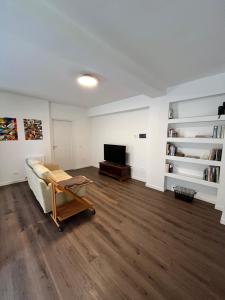 sala de estar con sofá y TV en HABITA appartamento primo piano, en LʼAquila