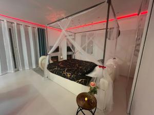a bedroom with a canopy bed in a room at Suite de Charme - So Chic So Romantic in Bellegarde