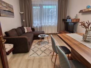 un soggiorno con divano e tavolo di Joy Apartman a Sovata