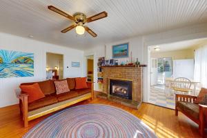 a living room with a couch and a fireplace at Captain John's Cannon Beach in Cannon Beach