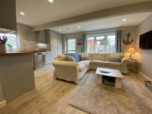 a living room with a couch and a table at The Hut- Private 1 Bed Guesthouse in Lymington Town Centre, garden & parking in Lymington
