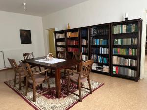 a dining room with a table and chairs and book shelves at B&B Maria Hart in Weert