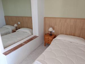a bedroom with two beds and a mirror at Hotel La Galera del Mar - Altea in Altea
