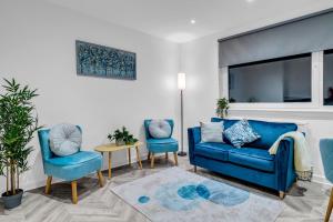 a living room with a blue couch and two chairs at Spital Stay - SJA Stays - Luxury 3 Bed Apartment in Aberdeen