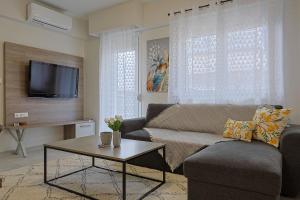 a living room with a couch and a table at Zeta - Garden Oasis & Private Parking in Katerini