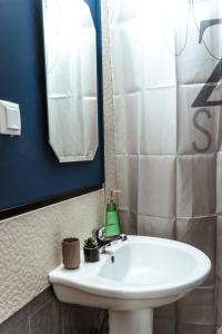 bagno con lavandino bianco e specchio di Casa Rosu a Cluj-Napoca