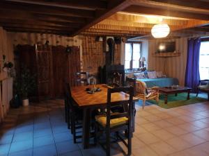 a dining room with a table and a living room at Gite Fée Grenouille in Martigny-le-Comte