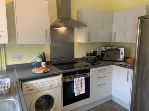 een keuken met een fornuis oven naast een vaatwasser bij Sea to City House in Whitley Bay