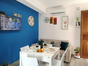サン・ヴィート・ロ・カーポにあるAppartamento Le Ginestreのダイニングルーム(白いテーブル、青い壁付)