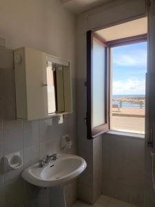 a bathroom with a sink and a window at Marger Apartments in Santa Maria di Castellabate