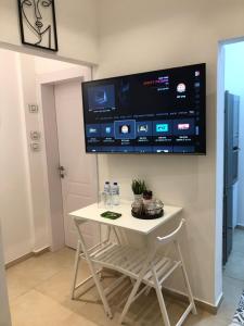 a white table with a tv on a wall at Boutique Suite Talia in Eilat