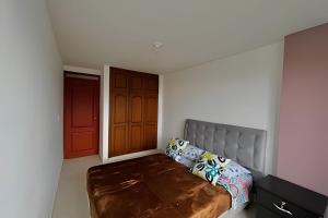 a bedroom with a bed and a red door at GURUS FR | Hermoso Apto. familiar con terraza | Santa Rosa in Santa Rosa de Cabal
