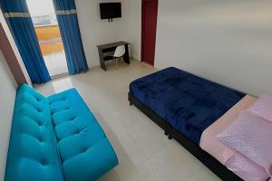 a bedroom with a blue bed and a desk at GURUS FR | Hermoso Apto. familiar con terraza | Santa Rosa in Santa Rosa de Cabal