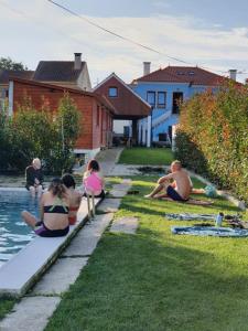 瓦倫薩的住宿－Alvorada Medieval, AL，一群人坐在游泳池边的草地上