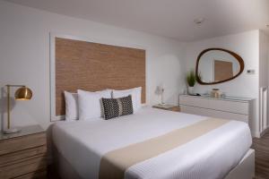 ein Schlafzimmer mit einem großen weißen Bett und einem Spiegel in der Unterkunft Stones Throw in York Beach