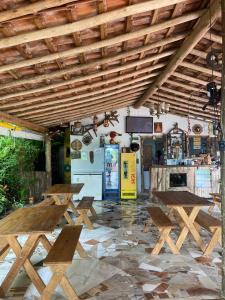 een restaurant met houten tafels en een koelkast bij Cantinho caipira in Aparecida
