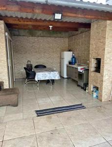 una cucina con tavolo e frigorifero di Aluga-se casa com piscina a Guarujá