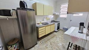 a kitchen with a stainless steel refrigerator in it at Ap confortável - Praia de Pitangueiras - Beach Host in Guarujá