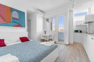 Un dormitorio blanco con una cama y una cocina. en Casa da Suite Stadium, en Milán