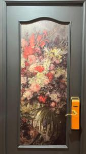 una pintura de un jarrón de flores en la puerta del baño en Hostal Inter Plaza Mayor, en Madrid