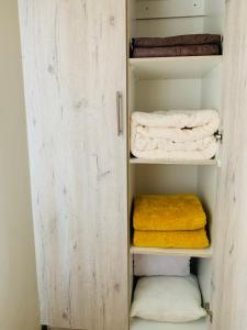 a closet with a door open with towels at Tsika's Inn in Gaborone