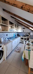 a large kitchen with white cabinets and a table at The house of dreams in Shkodër