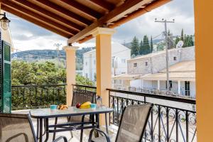 patio con mesa y sillas en el balcón en Nikos Cassiopeia, en Kassiopi