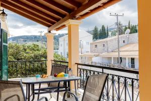 a patio with a table and chairs on a balcony at Nikos Cassiopeia in Kassiopi